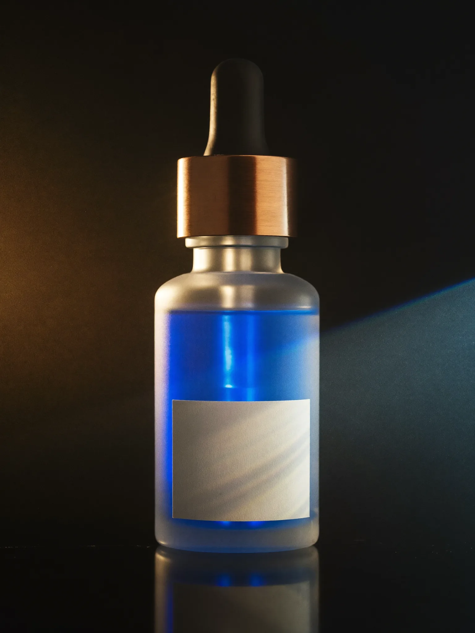 The SIGNAL dropper bottle: frosted grey glass, blue serum, copper collar